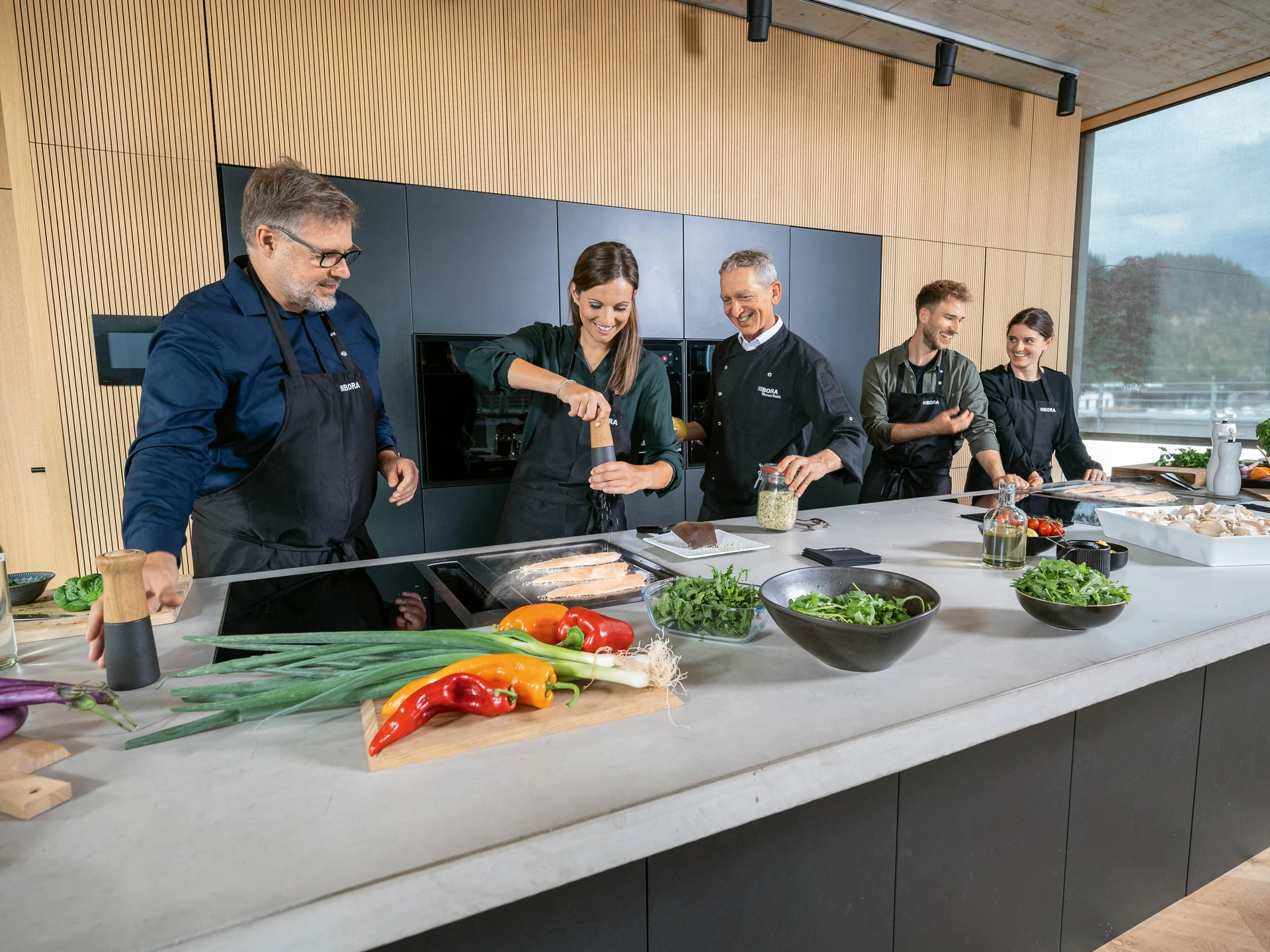 Mehrere Personen kochen gemeinsam an einer Bora Kochinsel